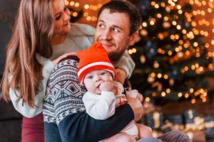 Father and mother spending time with their child in a Christmas-decorated room, enjoying family moments together