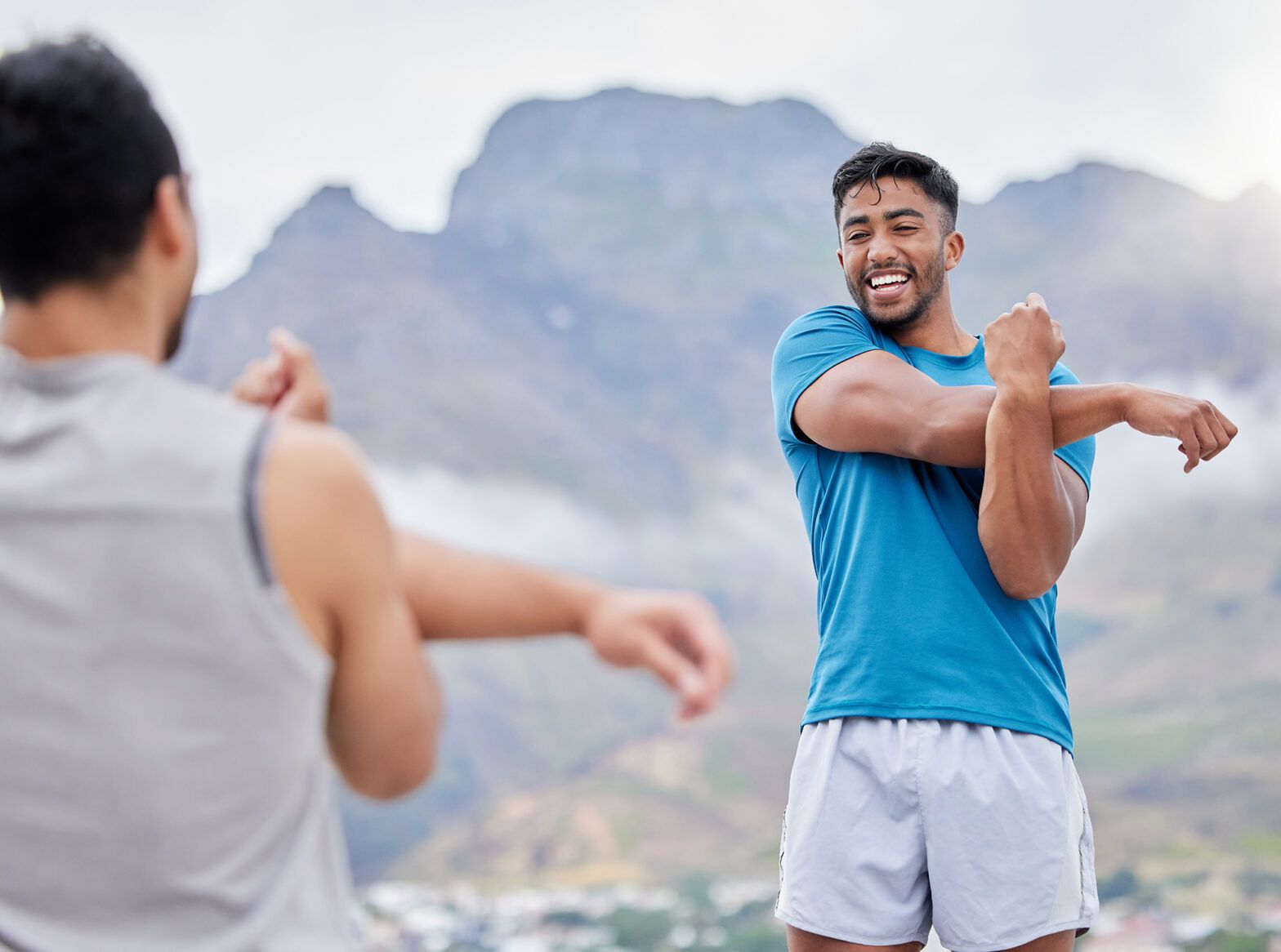 Friends getting ready to run on a mountain trail, enjoying outdoor exercise and fitness together
